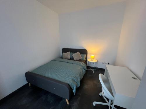 a small bedroom with a bed and a table at Sivas Ferienwohnung 2 in Ravensburg