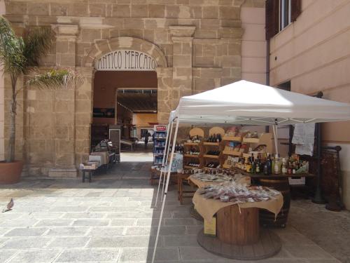 Un mercado con una sombrilla blanca al lado de un edificio. en Casa Bijou, en Marsala