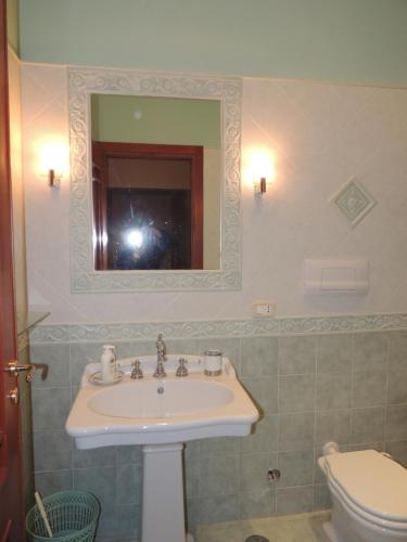a bathroom with a sink and a toilet and a mirror at Residenza Panoramica Villa Carmela in Rocca Cilento