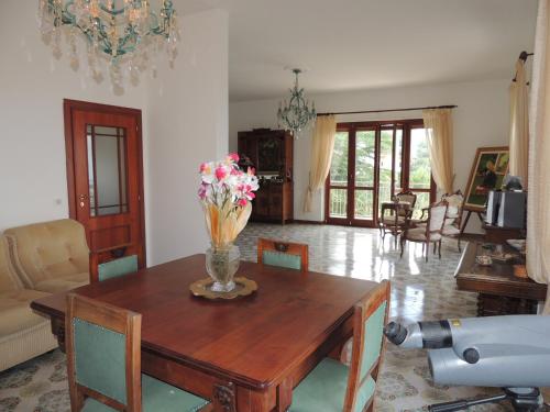 a living room with a wooden table with flowers on it at Residenza Panoramica Villa Carmela in Rocca Cilento