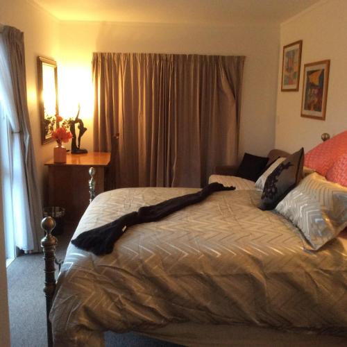 a bedroom with a bed with a long black blanket on it at Noah's Boutique Accommodation Moeraki in Moeraki