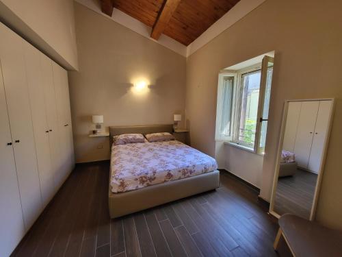 Un dormitorio con una cama, una ventana y un espejo. en Litos, en Bevagna