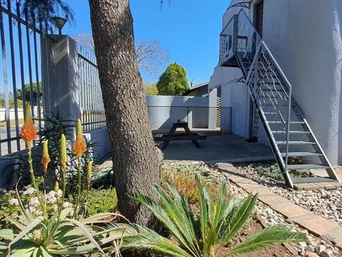a stairway leading up to a building with a tree at Middelbult Guesthouse by Heybert in Secunda