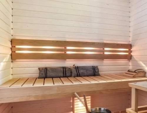 a sauna with a bench in a wooden room at Hienoa talo porealtaalla lähellä Helsinkiä ja lentokenttää in Tuusula