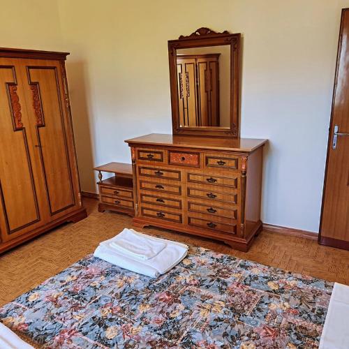 a bedroom with a dresser with a mirror and a bed at housecurti1 in Sorico