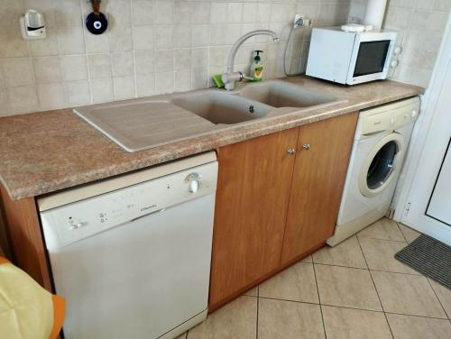 a kitchen with a sink and a washing machine at Villa Helen in ayios Petros