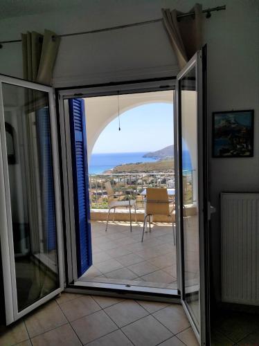 a sliding glass door with a view of the ocean at Villa Helen in ayios Petros