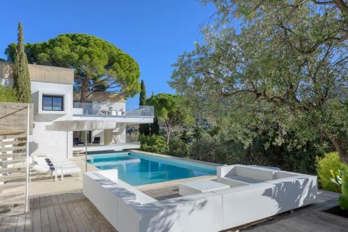 une piscine avec des meubles blancs et une maison dans l'établissement K-Sea Villa One - Villa Unique de Luxe à Cassis, à Cassis