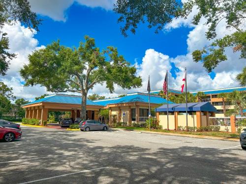 a building with cars parked in a parking lot at Hotel SonoHotel IDrive District in Orlando
