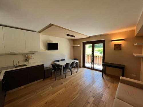 a kitchen and living room with a table and chairs at Appartamento in mezzo al verde in Sauze dʼOulx