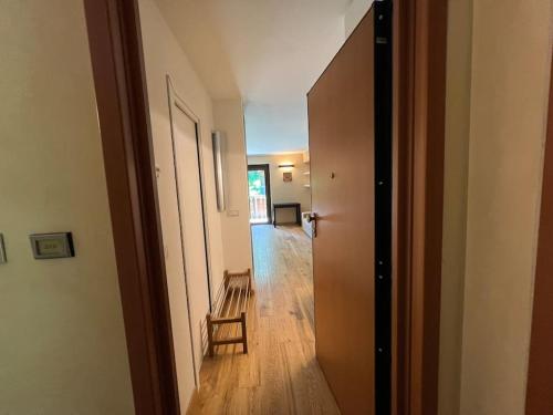 a hallway with a room with a chair and a table at Appartamento in mezzo al verde in Sauze dʼOulx