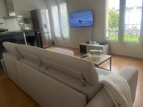 a living room with a couch and a table at WonderSuite appartement - centre ville avec parking couvert -15mn de Paris et 10 mn de Stade de France, wifi, Netflix in Deuil-la-Barre