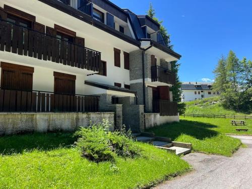 a building with a grassy yard in front of it at Appartamento in mezzo al verde in Sauze dʼOulx