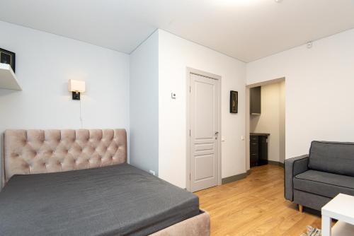 a bedroom with a bed and a couch and a chair at Fetingas in Šventoji