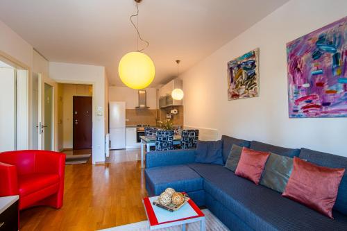 a living room with a blue couch and a red chair at Flexible SelfCheckIns 85 - Zagreb - Loggia - New in Zagreb