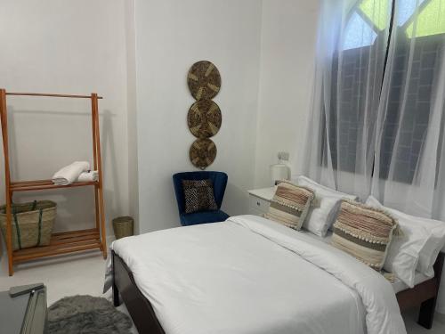 a bedroom with a white bed and a window at Nashu House Stone Town in Ngambo