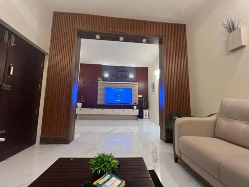 Una sala de estar con un sofá y un televisor. en Chakkaly villa, en Vayittiri