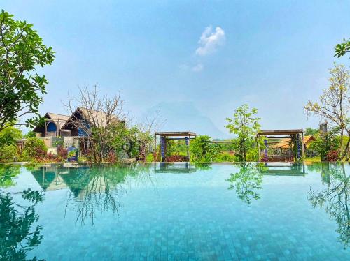 a large pool of water in front of a house at Yatika Boutique Chiang Dao in Chiang Dao
