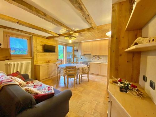 a kitchen and a living room with a couch and a table at Casa Clus Bormio apartments 2 in Valdisotto