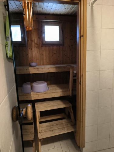 a small bathroom with wooden shelves and a window at Oravamökki in Sotkajärvi
