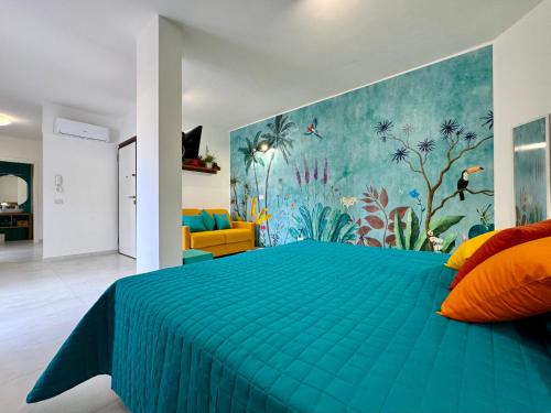 a bedroom with a blue bed with a painting on the wall at YourHome - Blu Jade House in Piano di Sorrento
