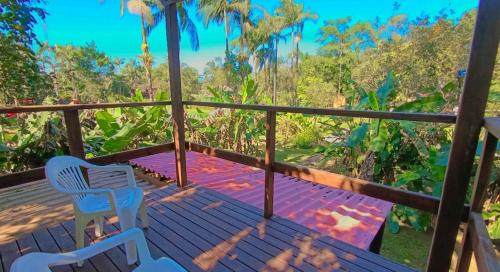 a balcony with two chairs and a view of the forest at Pousada e Restaurante Dona Siroba in Morretes