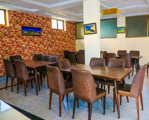 a dining room with tables and chairs and a brick wall at Yak Sarai Hotel & Restaurant in Skardu