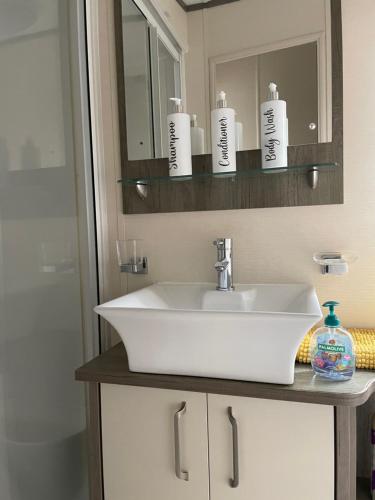 a bathroom with a white sink and a mirror at lake view staycations in Carnforth