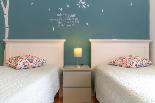 a bedroom with two beds and a blue wall at Atlantic Nest Coimbra in Coimbra