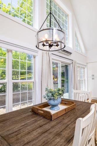 a dining room with a table with a vase on it at Tranquil Mountain Escape Luxurious 2 Bedroom 2 Bath Cottage on 9 Acres in Maryville