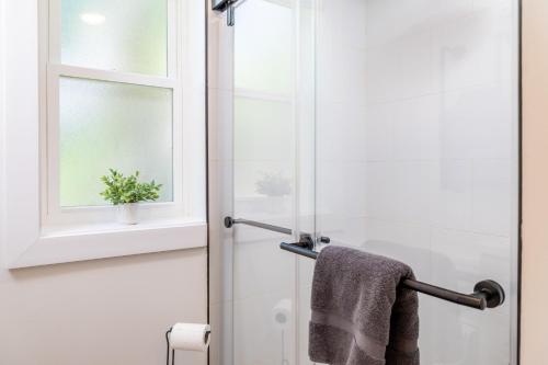 a bathroom with a shower with a towel and a window at Tranquil Mountain Escape Luxurious 2 Bedroom 2 Bath Cottage on 9 Acres in Maryville