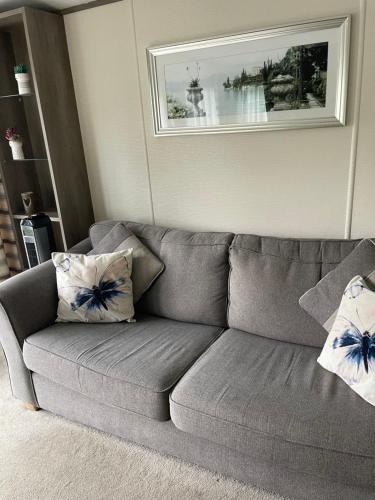 a gray couch with two pillows in a living room at lake view staycations in Carnforth