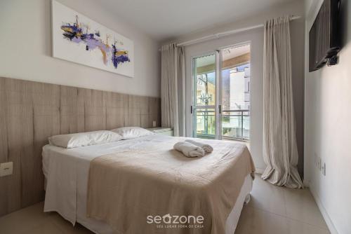 En eller flere senge i et værelse på RFO - Apartamentos a poucos passos da Praia de Bombinhas