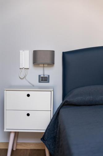 a bedroom with a bed and a nightstand with a lamp at Domus Xenia in San Giorgio a Cremano