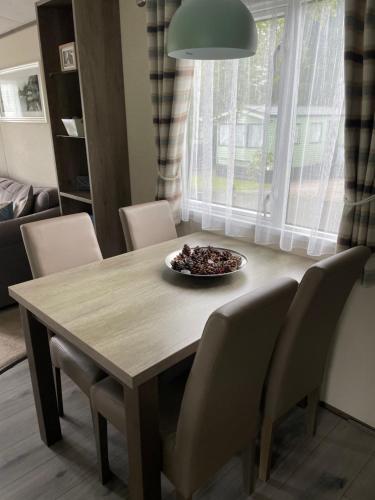 a dining room table with chairs and a bowl of food on it at lake view staycations in Carnforth