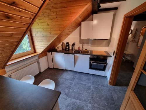 a kitchen with white appliances and a wooden ceiling at Schwalbennest in Daun