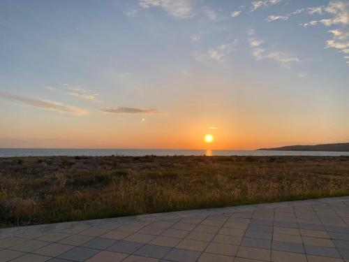 Una puesta de sol en la playa con la puesta del sol en Le Solite Holiday Rooms, en SantʼEufemia Lamezia