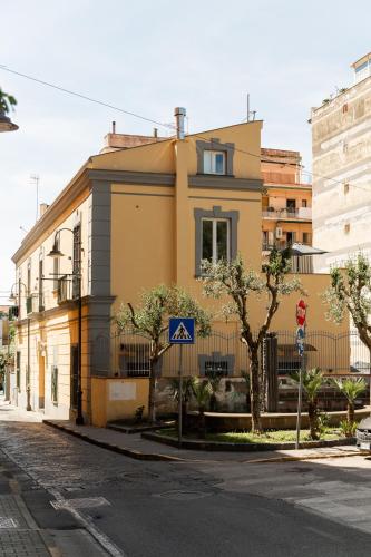 a yellow building on the side of a street at Domus Xenia in San Giorgio a Cremano