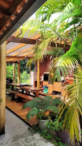 a patio with picnic tables and palm trees at Chales em Salesopolis - Recanto da Barra in Salesópolis