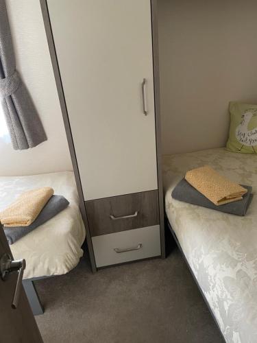 a bedroom with two beds and a mirror at lake view staycations in Carnforth