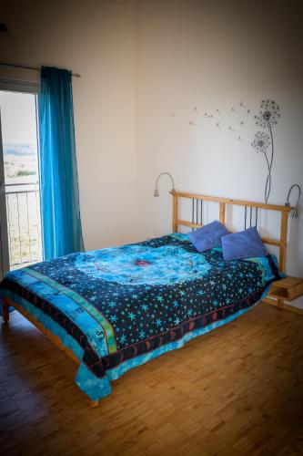 Un dormitorio con una cama con edredón azul y una ventana. en Kunsttraum, en Buxheim
