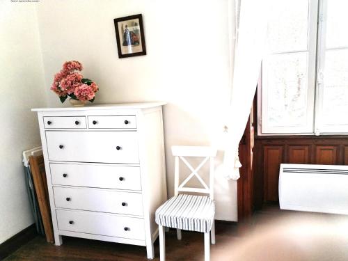 - une chambre avec une commode blanche et une chaise dans l'établissement BIARRITZ CENTRE tout à pied parking Wifi, à Biarritz