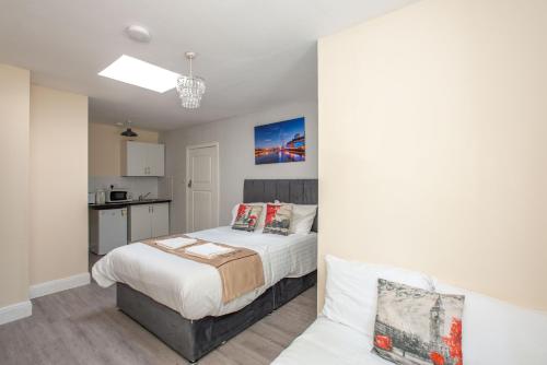a small bedroom with a bed and a kitchen at Saffron Studios in Orpington