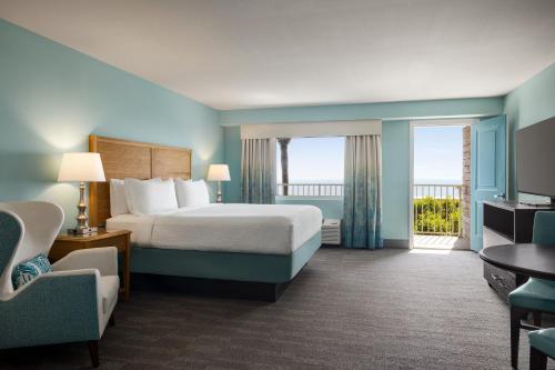 a hotel room with a bed and a balcony at Holiday Inn Resort Jekyll Island by IHG in Jekyll Island
