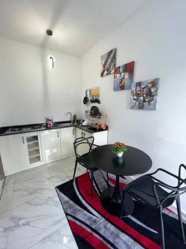 a kitchen with a table and chairs in a room at DMayors Apartments in Garki
