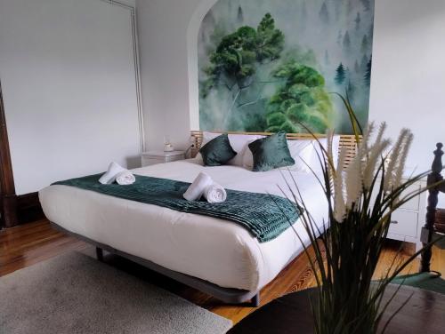 a bedroom with a bed with a painting on the wall at Chavarri Etxea, casa indiana XBI00149 in Biáñez