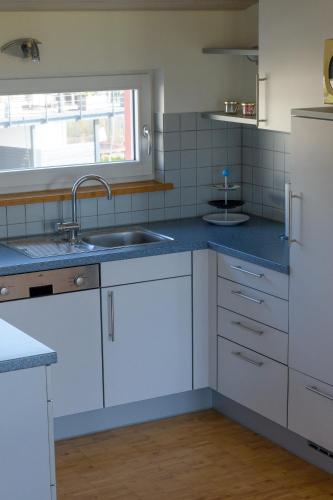 Una cocina con fregadero y refrigerador blanco. en Kunsttraum, en Buxheim