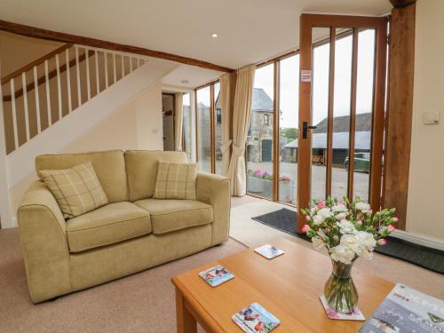 a living room with a couch and a table at Hunstone Barn in South Molton