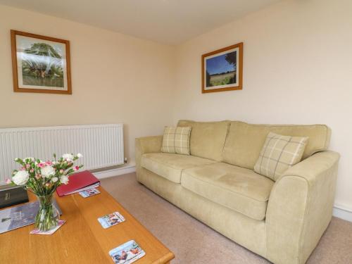 a living room with a couch and a table at Hunstone Barn in South Molton