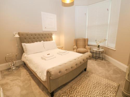 un dormitorio con una cama y una silla en Cavendish Suite, en Buxton